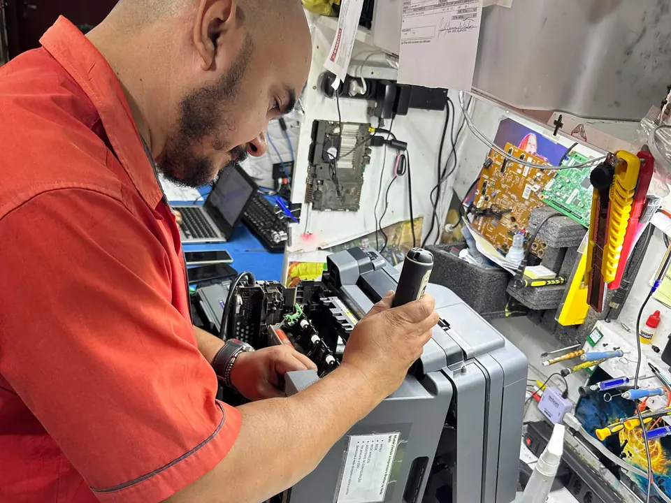 Técnico da Barbosa Informática fazendo manutenção em uma impressora